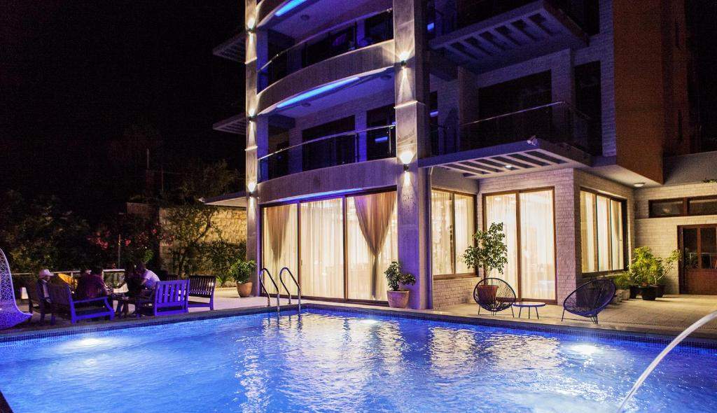 Hotel Velkom in Sutomore with its outdoor pool lit up in the evening